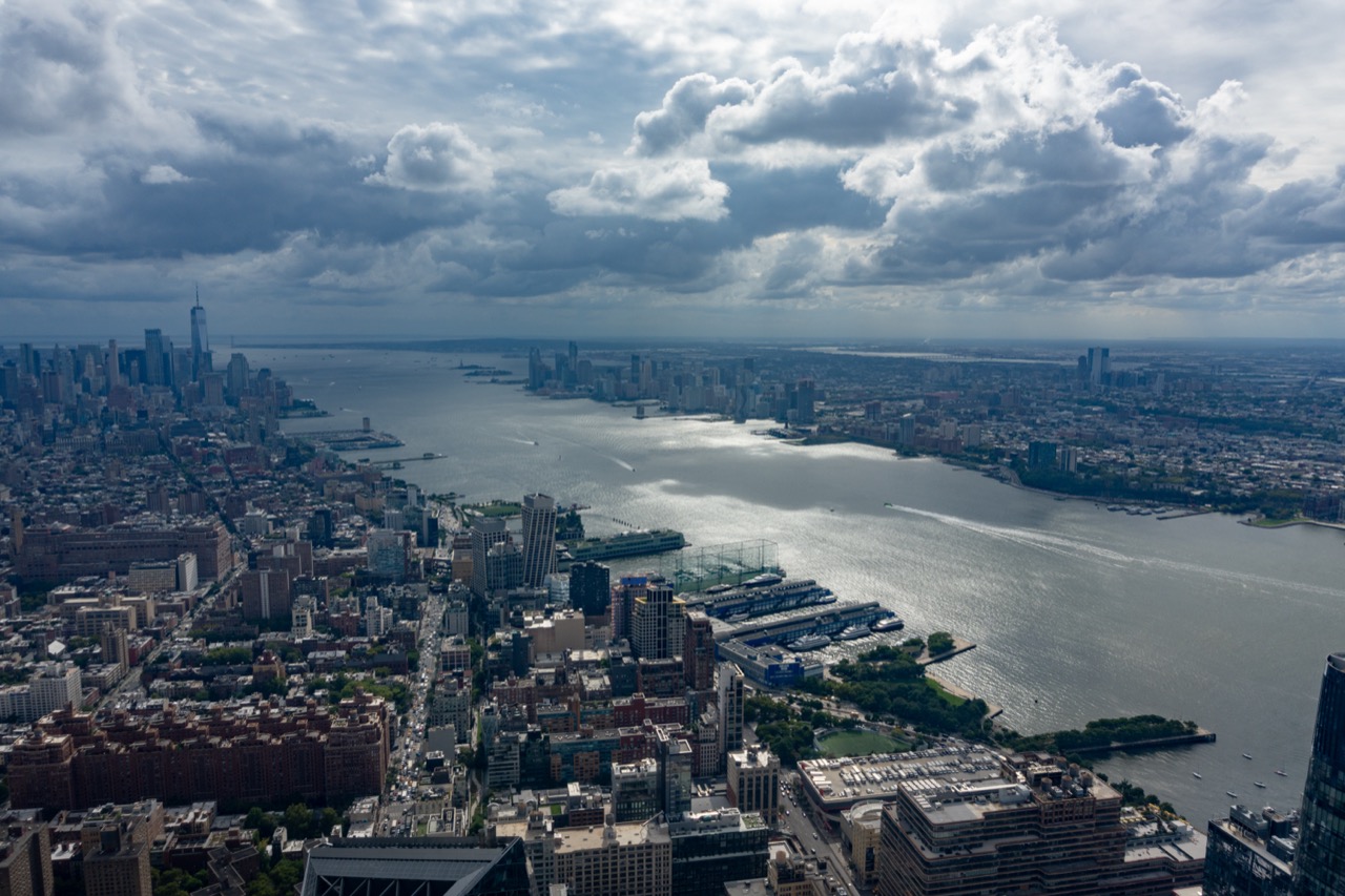 Aerial view over Lower Manhattan and the Hudson River under heavy clouds